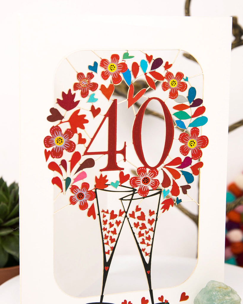 close up shot of the 40th Wedding Anniversary Card - Ruby Wedding Anniversary Card that features clanking champagne glasses surrounded with hearts | Dreamy London